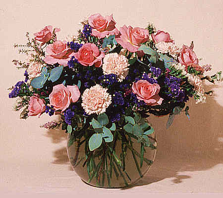 Roses and carnations arranged in a glass vase.