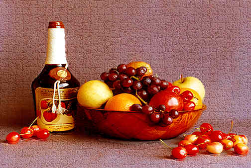 Photo of a bottle of strawberry wine and assorted fruit in a bowl